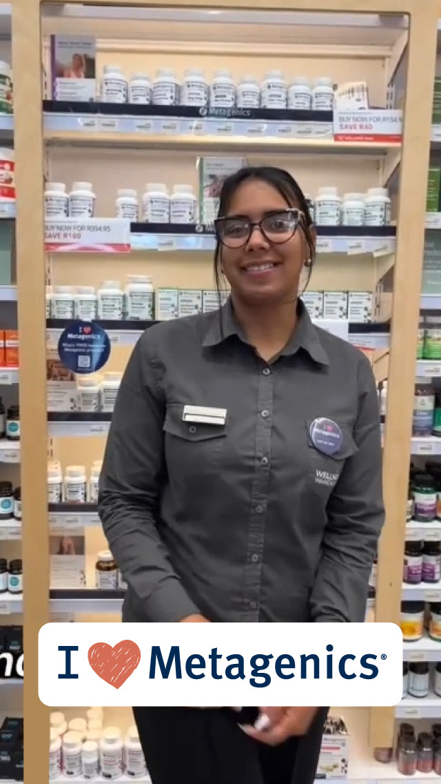 A wellness consultant from Wellness Warehouse standing in front of a Metagenics product display